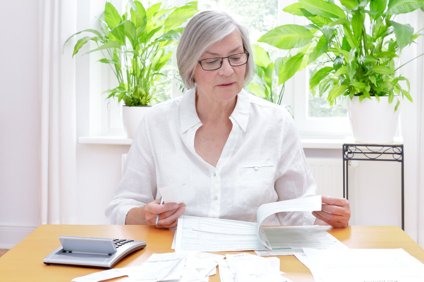 Une femme a un bureau entrain de lire des papiers